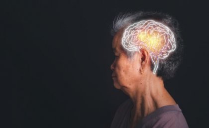 a woman with short grey hair looks to the left on a black background, a white superimposed drawing of a brain is on her head
